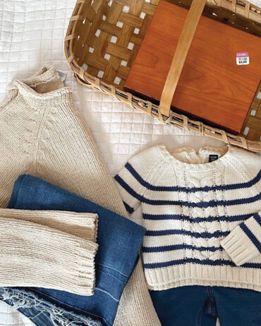 Photo of a sweater, jeans and basket on a bed.