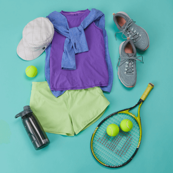 A hat, sleeveless shirt, shorts, jacket, water bottle, tennis balls and racket and tennis shoes.