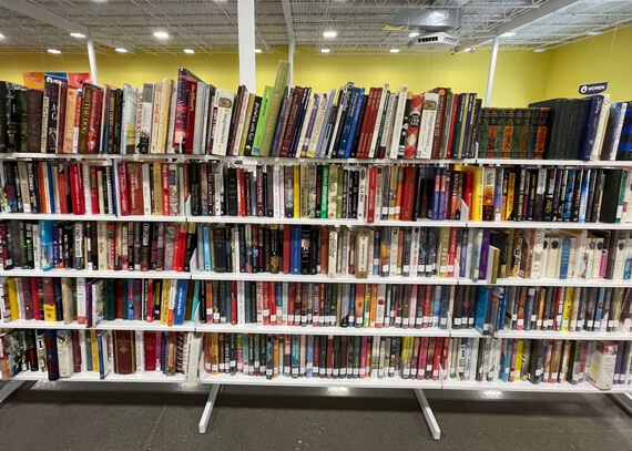 Photo of bookshelves with books on them at a Goodwill store.