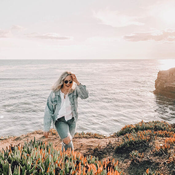 Photo of Haley walking on a cliff by the ocean.