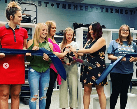 Photo of students in the Nest store cutting a ribbon to open the store.