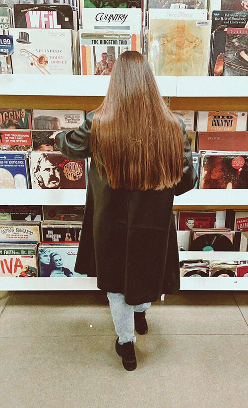 Woman shopping vinyl record section of Goodwill store