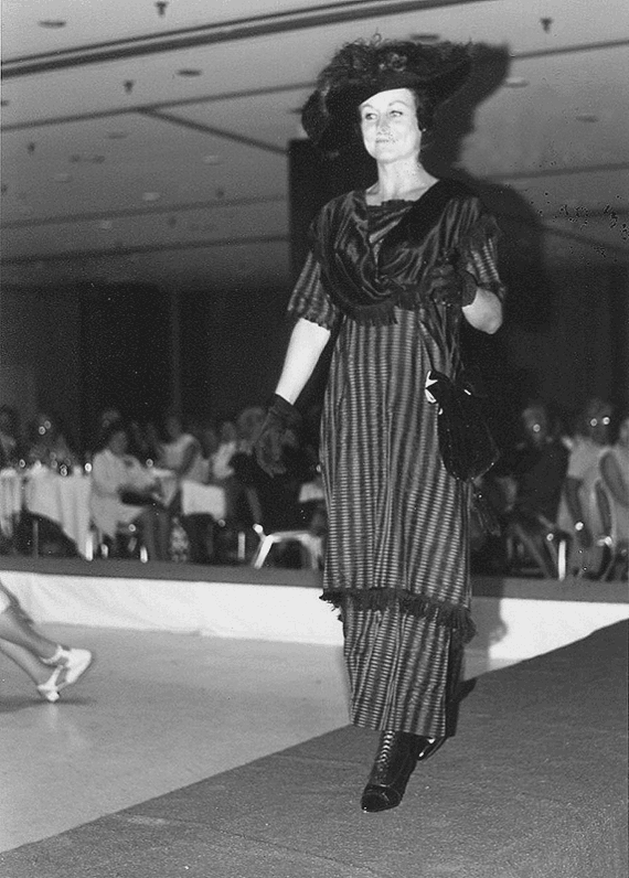 Photo of woman walking down a runway at a fashion show