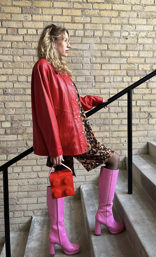 Woman walking up stairs with pink boots.
