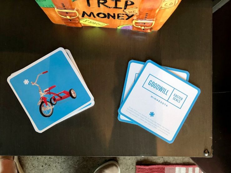 Goodwill coasters read "Every time you donate or shop for items like these, GESMN uses those proceeds to help people in need get jobs in their communities."