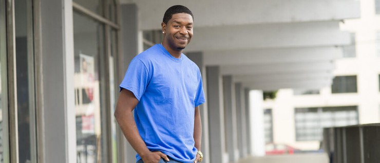 Photo of a man in a blue shirt smiling.