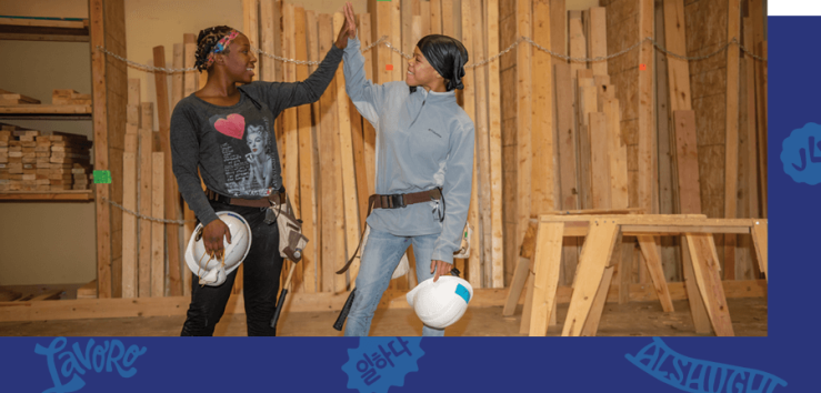 Photo of 2 women participants giving each other a high five in class.