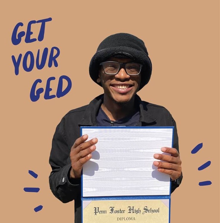 Photo of a participant smiling and holding their diploma.